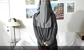 Eine fröhliche Muslimin präsentiert sich unter ihrer Kleidung